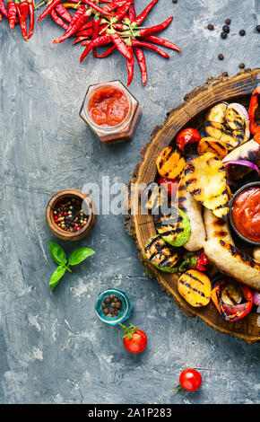 Gegrillte Würstchen gebraten mit Birne und Gemüse. Herbst essen. Stockfoto