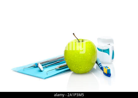 Der Zahnarzt medizinische Geräte Werkzeuge mit frischem Grün Apple dental health care konzeptionellen Hintergrund Bild. Stockfoto