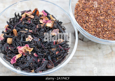 Lose schwarzer Tee aromatisierter Tee- und superior Rooibos in einem Glas Schale auf einem hölzernen Hintergrund der Ansicht von oben Stockfoto