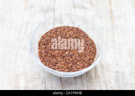 Loser Tee rooibos Superior in einem Glas Schale auf einem hölzernen Hintergrund der Ansicht von oben Stockfoto