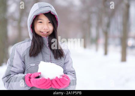 Portrait von Asiatischen jugendlich Holding einen Schneeball in den Händen Stockfoto