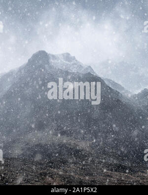 Atemberaubende Moody dramatische Winterlandschaft mountain Bild von schneebedeckten Y Garn in Snowdonia Stockfoto