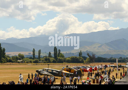 Airshow-Publikum bei der Wings Over Wairarapa Air Show am Hood Aerodrome, Masterton, Wairarapa, Neuseeland. Landschaft, Hügel. De Havilland Moskito fliegen Stockfoto