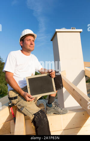 Junge Arbeitnehmer hält ein Schild in der Hand. Stockfoto
