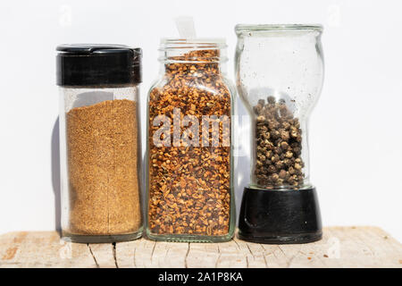 Drei Gläser mit Gewürzen verschiedener Schleifen auf weißem Hintergrund Stockfoto