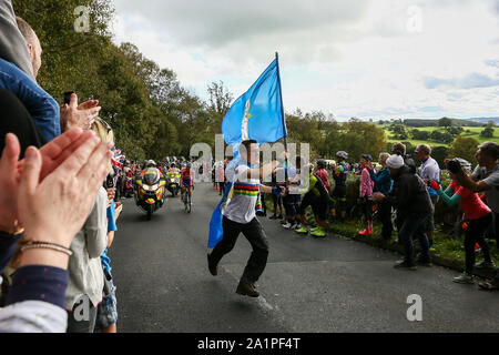 Harrogate, Großbritannien. 28 Sep, 2019. Ein Ventilator drapiert in Yorkshire flags jagt Mitfahrer auf den ersten Anstieg des Tages an der 2019 UCI Road World Championships Frauen Elite Straße Rennen. September 28, 2019 Credit Dan-Cooke/Alamy leben Nachrichten Stockfoto