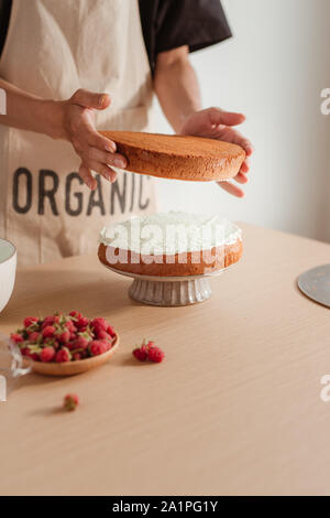 Pastry Chef setzt Kuchen Schicht auf einem Kuchen. Die kuchen Prozess Stockfoto