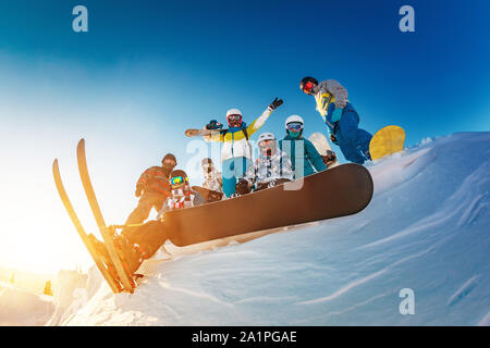 Große Gruppe von Glücklich Skifahrer und Snowboarder Stellen gegen den blauen Himmel Stockfoto