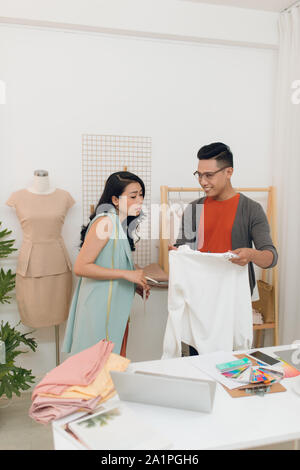 Zwei Mode-Designer arbeiten gemeinsam an einem Tisch Stockfoto