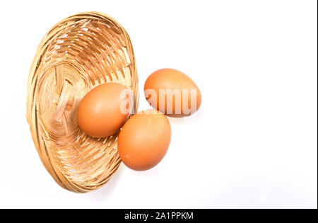 Blick von oben auf die drei braune Eier in Rattan Korb auf weiße Oberfläche mit Kopie Raum Stockfoto