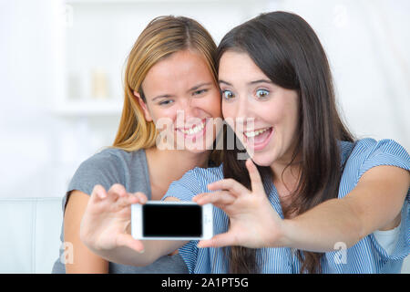 Junge weibliche Freunde ziehen lustiges Gesicht für selfie Foto Stockfoto