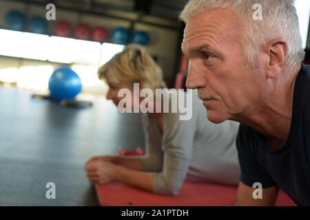 Senior Paar in der Turnhalle in Ganzkörperstütz arbeiten abs Stockfoto