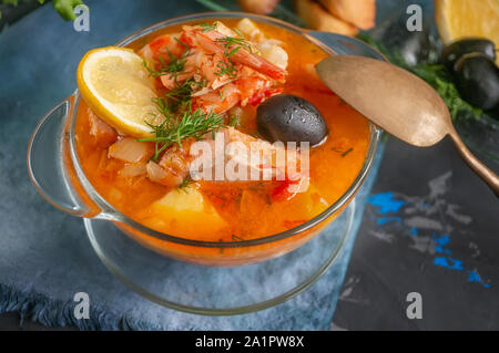 Meeresfrüchtesuppe, Lachs und Kabeljau mit Kartoffeln. Nationale Suppe der französischen Fischer. Mit Zitronen und Oliven serviert. Stockfoto