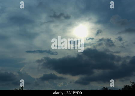 Das Sonnenlicht dringt durch Gewitterwolken verlassen ein dunkles Licht in den Himmel Stockfoto