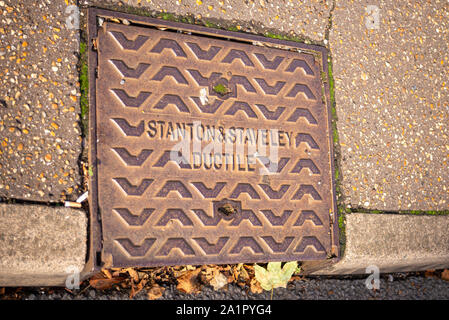 Einstiegöffnung Abdeckung in Southend On Sea, Essex, Großbritannien. Stanton & Staveley Duktilität. Aufkantung Kanaldeckel mit Blätter im Herbst Stockfoto