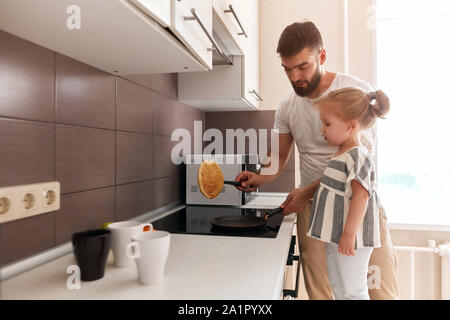 Stattliche Vati und seine bezaubernde Tochter Pfannkuchen Vorbereitung in der Küche. Lifestyle, Freizeit, Freizeit. Kopieren Sie Platz Stockfoto