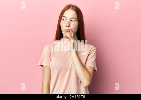 Nachdenklich ernsten jungen Frau beiseite, Hand auf das Gesicht, als ob es ist schwer etwas wichtig, daran zu erinnern. Menschliches Gesicht ausdrücken und emoti Stockfoto