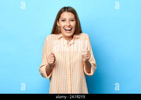 Junges attraktives Mädchen ist glücklich, als sie das Ziel erreicht hat, Frau, Glück in der Lotterie gewonnen hat, isolierte blauen Hintergrund. Glück Stockfoto