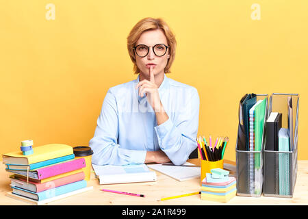 Seriöse Geschäftsfrau mit einem Finger auf ihre Lippen, die Stille Geste, die Lehrer, die Schüler zu beruhigen, aufhören zu reden. nach oben Porträt schließen, Isola Stockfoto