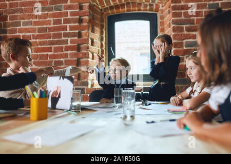 Young Business Kinder miteinander zeigt, dass ein agument im Loft Zimmer. Bis schließen Foto Stockfoto