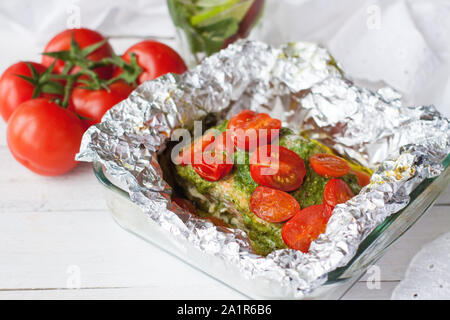 Zubereitung von Lachs in Folie gebacken mit Pesto, Tomaten und Spargel Stockfoto