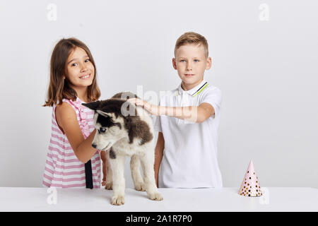 Schöne Mädchen und gut aussehende junge haben ein Geschenk zum Geburtstag erhalten, bis Foto schliessen. weißem Hintergrund, studio Shot, freie Zeit, spar Stockfoto