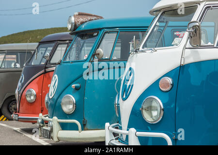 Reihen von Classic Volkswagen Wohnmobile an porthtowan Strand Parkplatz an der West Küste von Cornwall, England, Großbritannien. Stockfoto