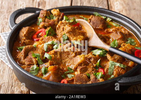 Kaschmir Lamm Rogan Josh mit Gewürzen und Soße close-up in einer Pfanne auf dem Tisch. Horizontale Stockfoto