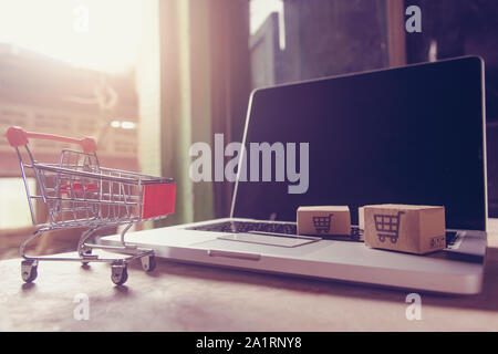 Online Shopping Konzept-Paket oder Kartons mit einem Warenkorb Logo in einem Trolley auf einem Laptop Tastatur. Shopping Service auf der on-line-Web. Stockfoto