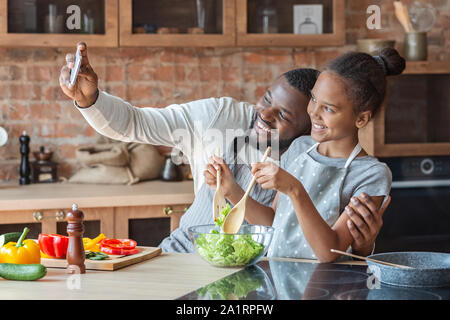 Freundliche Vater und Tochter unter selfie beim Kochen in der Küche Stockfoto