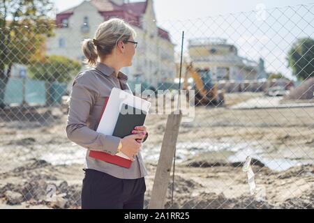 Portrait von Business reife Geschäftsfrau auf der Baustelle Instandsetzung der Straße in der Stadt, Pflasterstein Festlegung Stockfoto