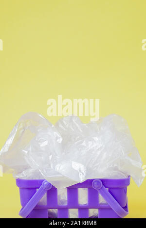 Polyäthylenbeutel im Warenkorb auf gelbem Hintergrund Stockfoto