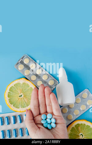 Medikamente, Pillen, Thermometer, traditionelle Medizin für die Behandlung von Erkältungen, Grippe, Wärme auf einem blauen Hintergrund. Aufrechterhaltung der Immunität. Saisonale Krankheiten Stockfoto
