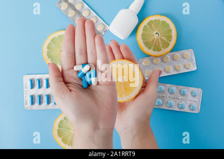 Medikamente, Pillen, Thermometer, traditionelle Medizin für die Behandlung von Erkältungen, Grippe, Wärme auf einem blauen Hintergrund. Aufrechterhaltung der Immunität. Saisonale Krankheiten Stockfoto