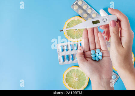 Medikamente, Pillen, Thermometer, traditionelle Medizin für die Behandlung von Erkältungen, Grippe, Wärme auf einem blauen Hintergrund. Aufrechterhaltung der Immunität. Saisonale Krankheiten Stockfoto