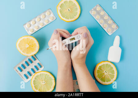 Medikamente, Pillen, Thermometer, traditionelle Medizin für die Behandlung von Erkältungen, Grippe, Wärme auf einem blauen Hintergrund. Aufrechterhaltung der Immunität. Saisonale Krankheiten Stockfoto