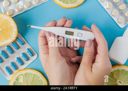 Medikamente, Pillen, Thermometer, traditionelle Medizin für die Behandlung von Erkältungen, Grippe, Wärme auf einem blauen Hintergrund. Aufrechterhaltung der Immunität. Saisonale Krankheiten Stockfoto