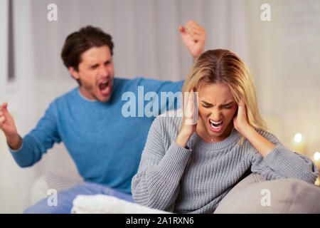 Aggressive Menschen Schreien Freundin sitzt auf einem Sofa zu Hause Stockfoto