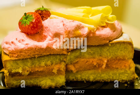 Köstliche geschnitten Erdbeer Sahne Kuchen mit Erdbeeren und weiße Schokolade dekoriert Stockfoto