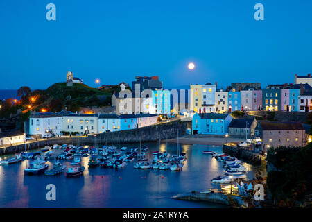 TENBY, WALES - 13. SEPTEMBER 2019: volle Mond scheint über historischen Hafen und dem Strand in Tenby, Wales. Stockfoto