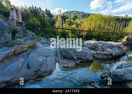 Hölzerne Brücke über Fluss in den Bergen gegen Berge in La Cumbrecita, Córdoba, Argentinien Stockfoto