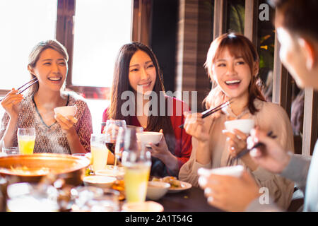 Glückliche junge Freunde genießen Sie ein Abendessen im Hot Pot Restaurant Stockfoto