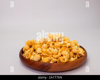 Hölzerne Schüssel voll mit süßem Karamell Popcorn Stockfoto