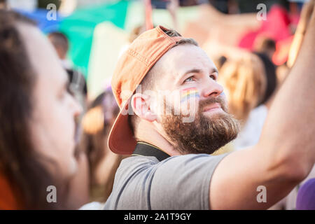 Belgrad, SERBIEN - September 15, 2019: Der Mann mit der Regenbogenfahne auf seinem im Jahr 2019 Belgrade Gay Pride, denen dies geschah, protestieren Gesicht malen Stockfoto