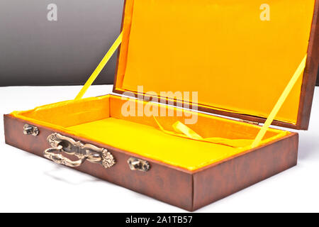 Leere Box mit gelben Innenfutter auf weiße Oberfläche und grauer Hintergrund Stockfoto