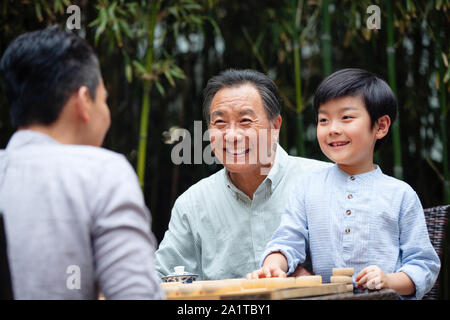 Drei Menschen Schach spielen zwischen den beiden Generationen Stockfoto