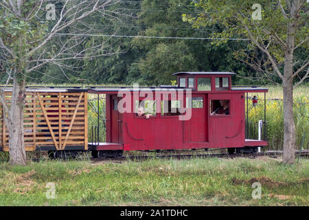 Hesston IN USA, 31. August 2019; ein kleiner Junge schaut aus dem Fenster eines kleinen roten Caboose, als er genießt eine Fahrt auf dieser Miniatur Zug am Hesston Stockfoto