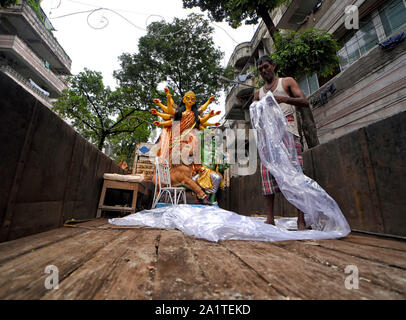 Kolkata, West Bengal, Indien. 28 Sep, 2019. Eine Künstlerin, die den Götzen mit einem Kunststoff Papier für Regen Schutz, während die Idole von Devi Durga vom Künstler Nabe zu verschiedenen Pandals (temporäre Plattform für die Anbetung von Idolen). Durga Puja durchgeführt werden, ist die größte hinduistische Fest der Hindus, die vom 5. Oktober 2019 beginnen. Credit: Avishek Das/SOPA Images/ZUMA Draht/Alamy leben Nachrichten Stockfoto