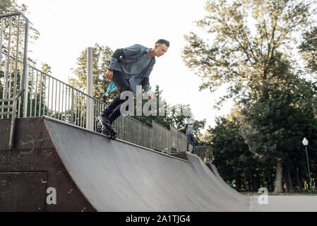 Roller Skating, jungen Skater rollt die Rampe Stockfoto