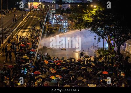 Hongkong, China. 28 Sep, 2019. Hong Kong Polizei zerstreuen Demonstranten mit Wasserwerfern Jets während der Demonstration. Demonstrationen in Hongkong in einer anderen Nacht der Proteste während der Feierlichkeiten zum fünften Jahrestag der Regenschirm Bewegung am Tamar Park fort. Credit: SOPA Images Limited/Alamy leben Nachrichten Stockfoto